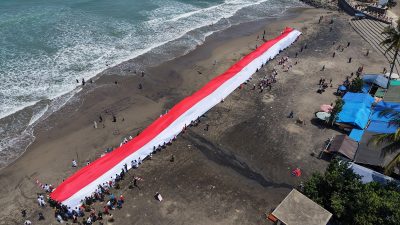HUT ke-81 RI, Perdana! Merah Putih 100 Meter Membentang di Pantai Karanghawu Sukabumi